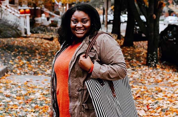 Entrepreneur Erika Green stands outside with purse she created.