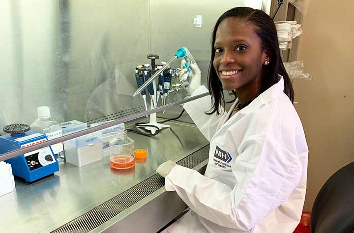 Rochelle in lab coat doing research in the lab.