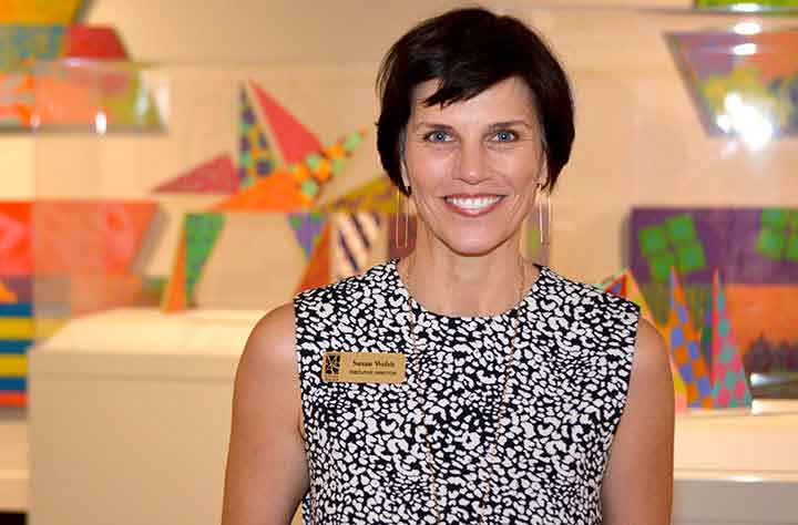 Susan Welsh stands in front of Artwork in the Museum of Arts and Sciences gallery.