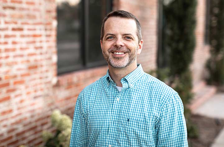 Faculty member Michael McGhee smiles for the camera in front of Wesleyan Organ