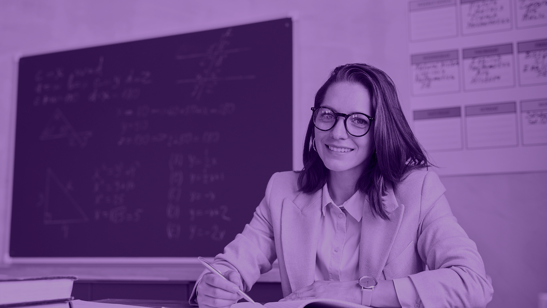 Photo depicting a female teacher in front of a blackboard