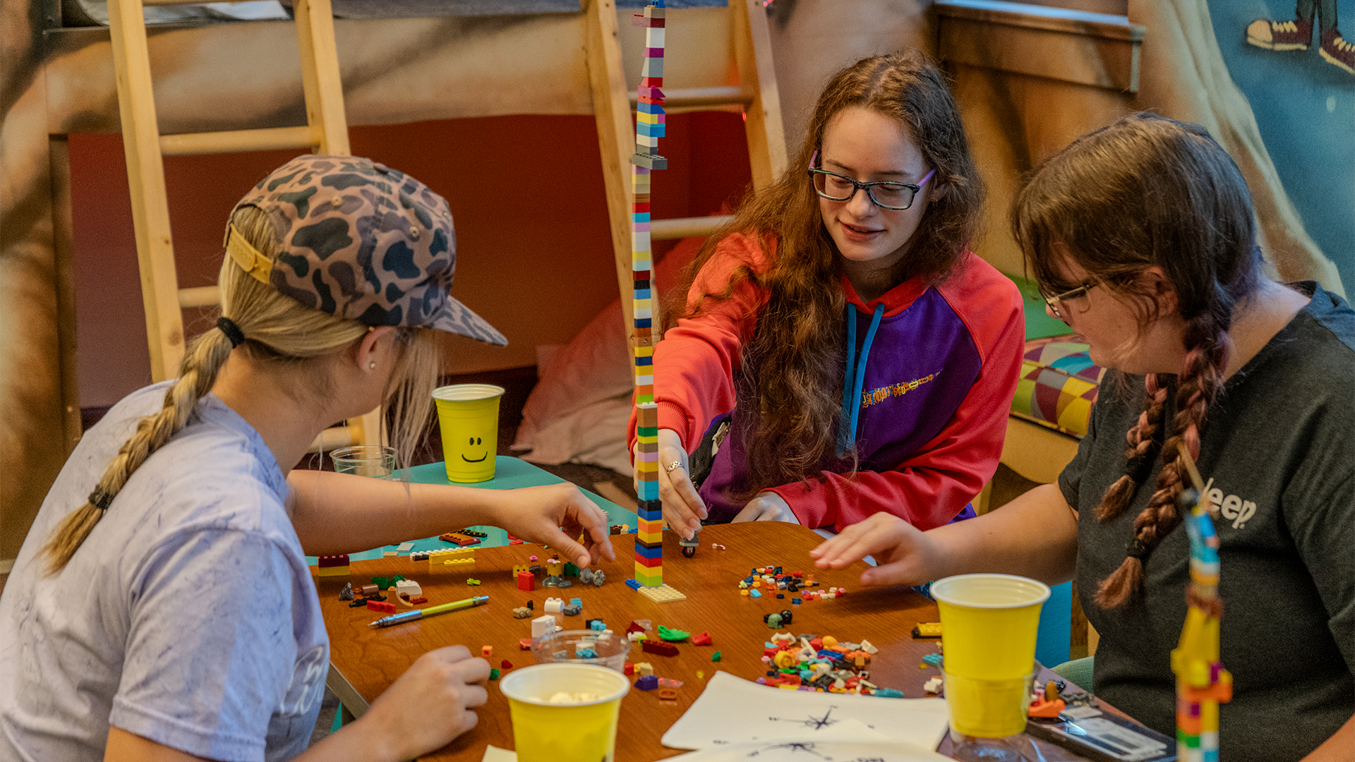 Students around a table creating a project out of LEGO blocks