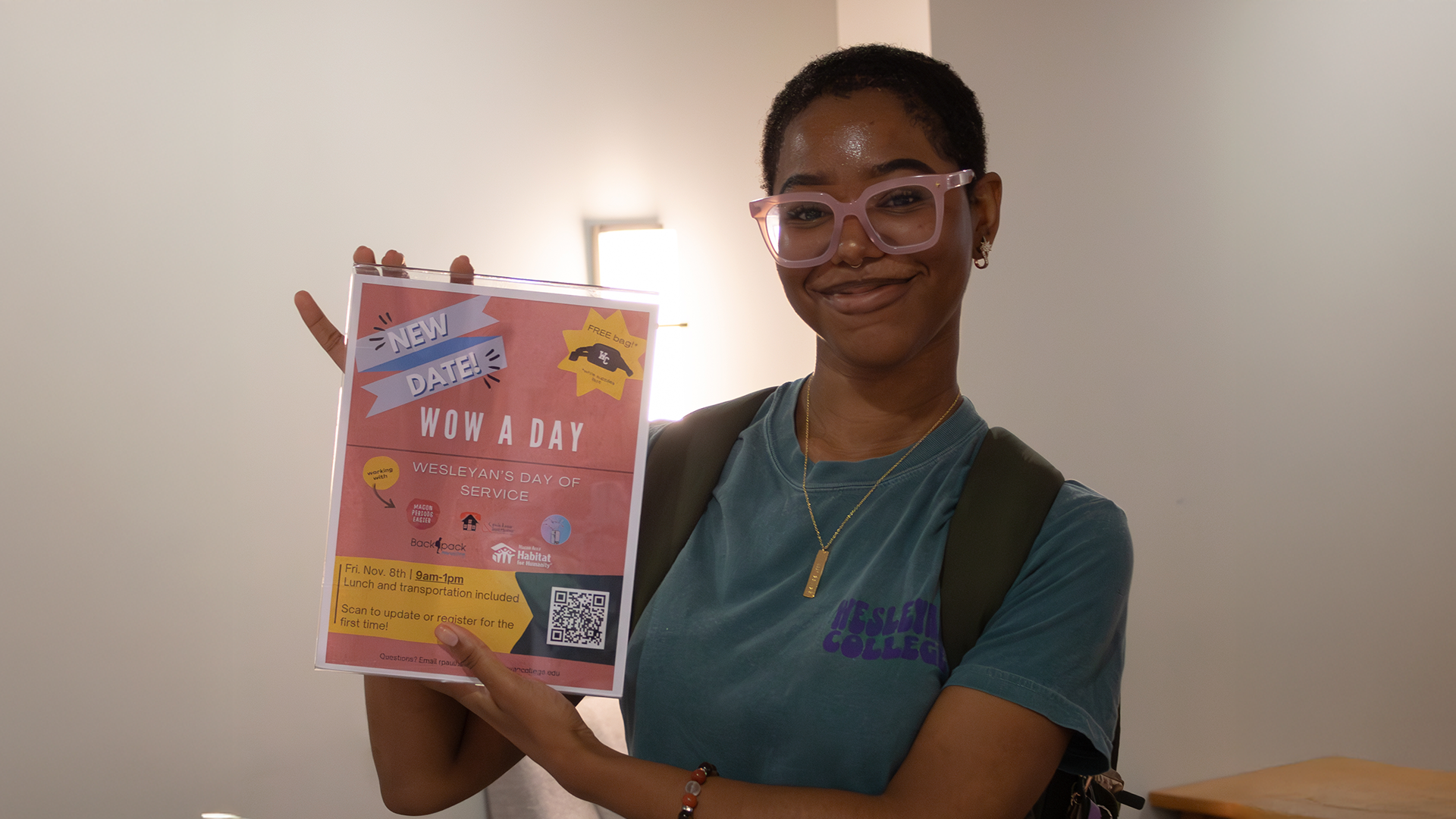 Student holding up a sign promoting a community service event