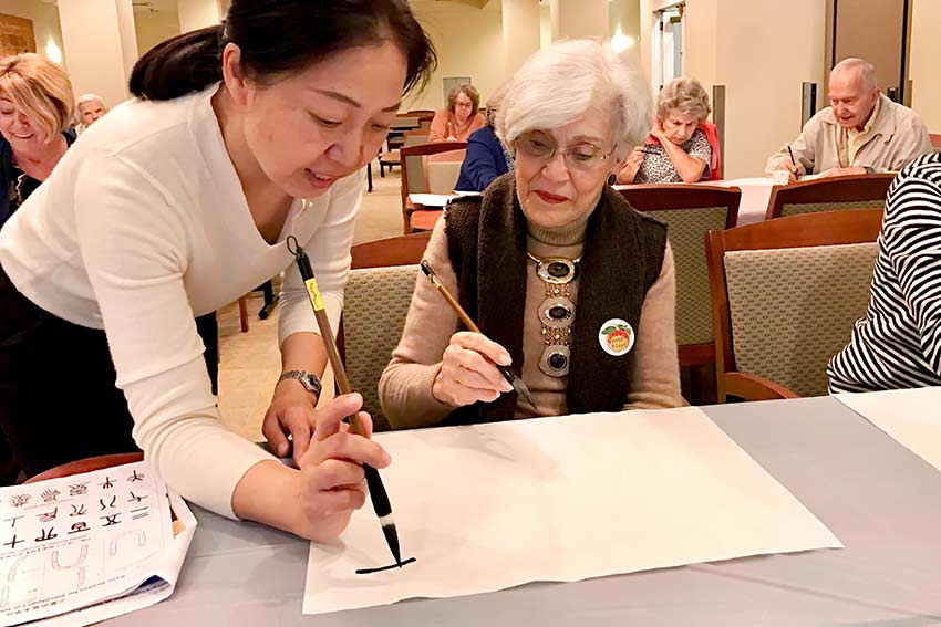 WALL students and instructor writing chinese letters.