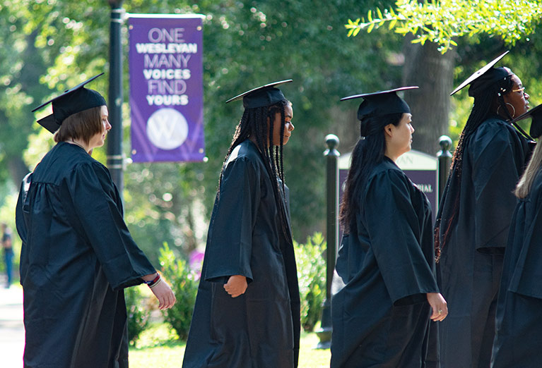 Students walk in regalia to convo