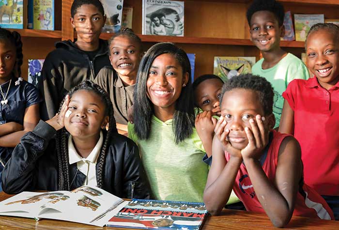 Wesleyan student volunteering with group of young students