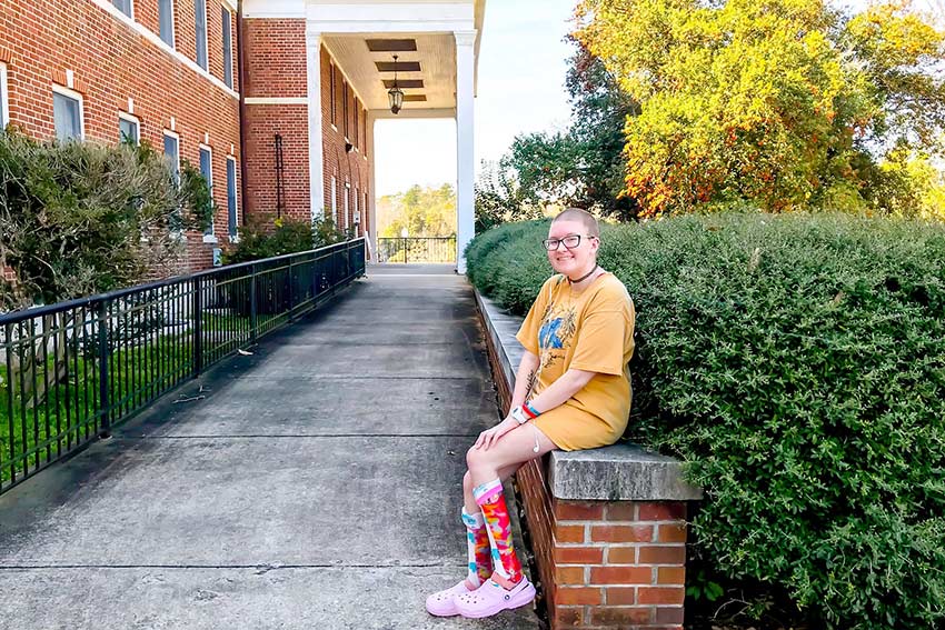 Student sitting outside of Persons Residence Hall